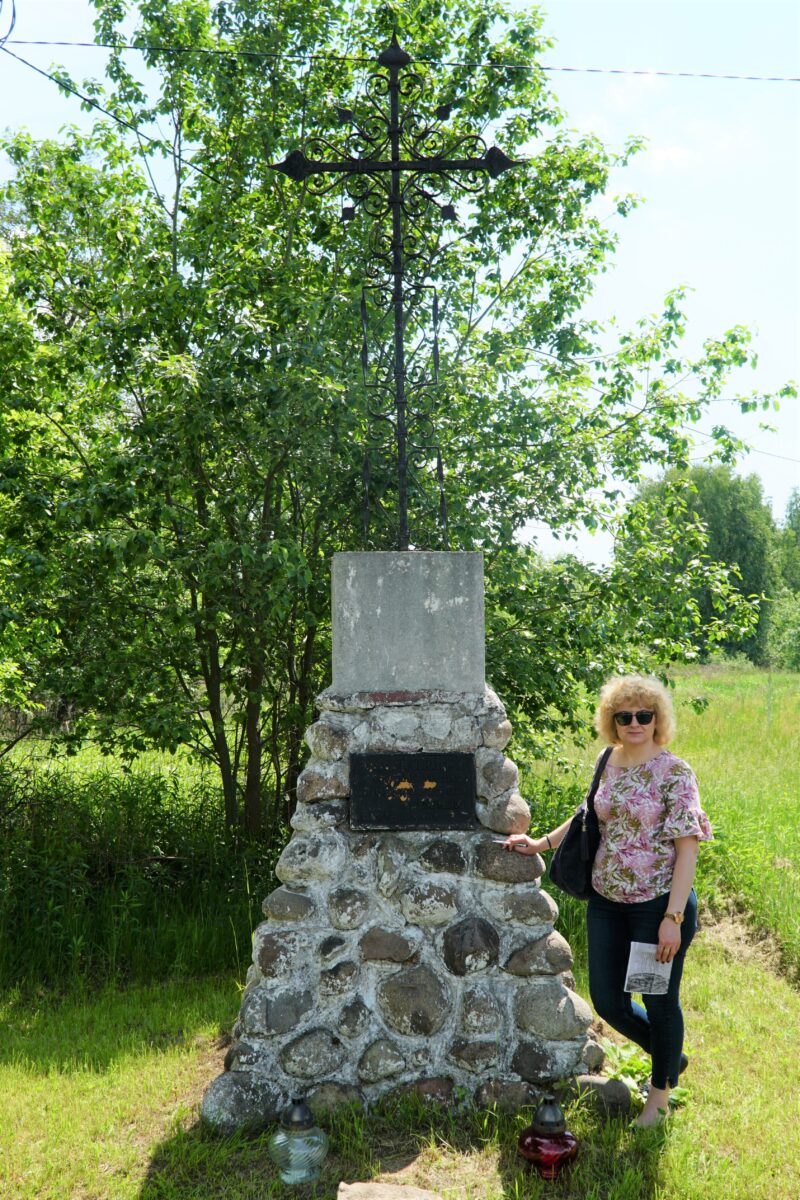 kobieta przy pomniku z krzyżem
