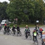 Ucszstnicy rajdu rowerowego jadący przez ulice gminy oraz podczas poczęstunku na mecie.
