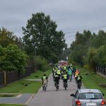 Ucszstnicy rajdu rowerowego jadący przez ulice gminy oraz podczas poczęstunku na mecie.