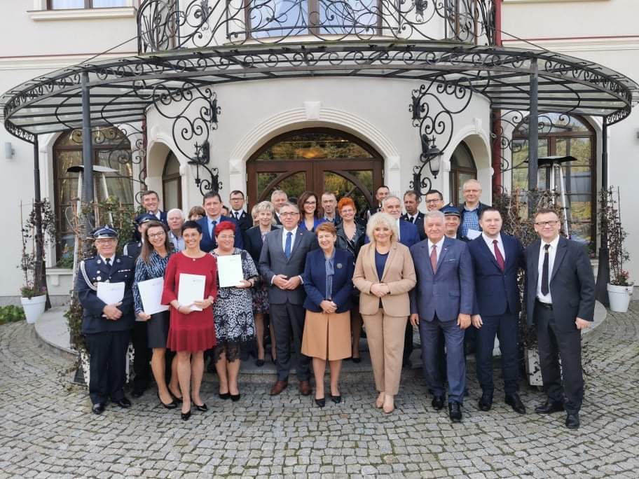 Kilkanaście osób na tle budynku