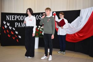 Kilka osób w tle flaga Polski