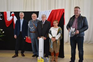 Kilka osób w tle flaga Polski