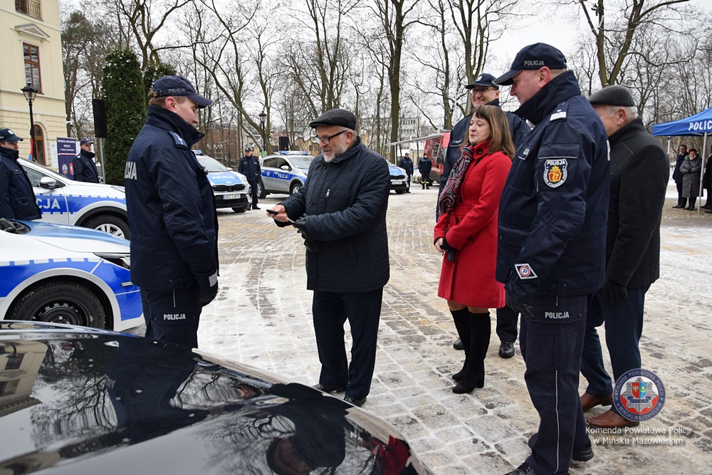 172-217225 Kilka osób przy samochodzie policyjnym