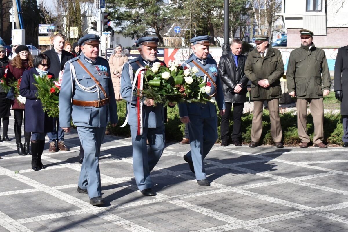 Trzech mężczyzn w mundurach z kwiatami