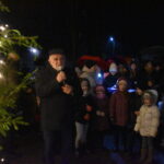 DSC_0053 Mężczyzna trzymający mikrofon, z lewej strony drzewko świąteczne