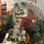 383 Biały wianek ozdobiony niebieskimi i białymi bombkami, szyszkami, plasterkami pomarańcza, białym kwiatem.