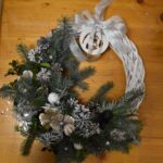 418 Biały wianek ratanowy w zimowej kolorystyce wykonany z jodły świerku, przyprószonych gałązek śniegiem, białych i czarnych bombek