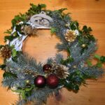 453 Wiszący biały ratanowy wianek, ozdobiony pomarańczami, szyszkami,gałązkami jodły, świerku i białą gwiazdą betlejemską.