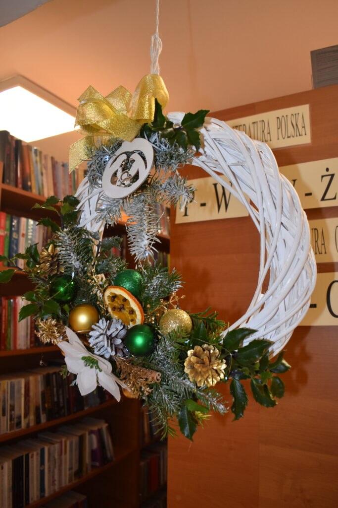 453 Wiszący biały ratanowy wianek, ozdobiony pomarańczami, szyszkami,gałązkami jodły, świerku i białą gwiazdą betlejemską.