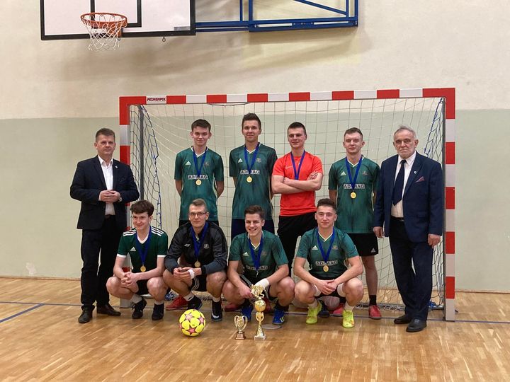 Kilku piłkarzy i dwóch mężczyzn w garniturze.