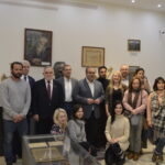 Kilkanaście osób na tle popiersia Piłsudskiego