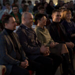 Kobieta z krótki włosami, obok policjant. w Tle widoczni ludzie.