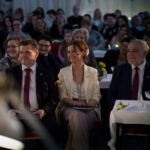 Publiczność siedząca na czerwonych krzesłach