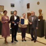 $ osoby dorosłe oraz kilkunastoletnia dziewczynka. Kobieta trzyma dyplom.