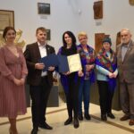 $ osoby dorosłe oraz kilkunastoletnia dziewczynka. Kobieta trzyma dyplom.