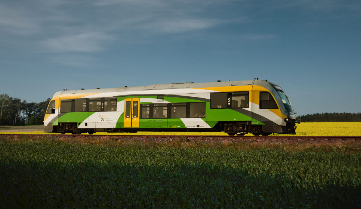 Pociąg zajeżający na stację kolejową.