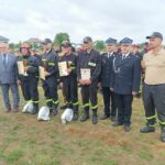 mężczyzna wręczający nagrodę strażakowi