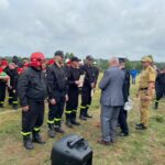 mężczyzna wręczający nagrodę strażakowi