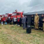 mężczyzna wręczający nagrodę strażakowi