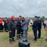 mężczyzna wręczający nagrodę strażakowi