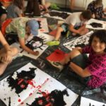 usmiechniety chlopiec obok kartki z czarnymi plamami