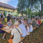 stoły i ławki zajęte przez ludzi