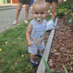 dziecko ze smoczkiem przy krawężniku