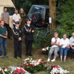 kwiaty biało czerwone grób zielona trwawa ludzie