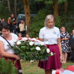 kwiaty biało czerwone grób zielona trwawa ludzie