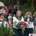 kwiaty biało czerwone grób zielona trwawa ludzie