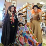 256 W bibliotece na tle regałów z książkami trzy dziewczynki i dwóch chłopców przebrane za postaci z bajek i kolorowy dzik zrobiony przez dzieci