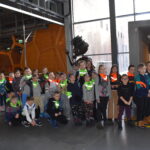 78 Chłopcy i dziewczynki stoją w grupce za nimi widać robota