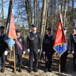 Na obrazku widać grupę mężczyzn, którzy trzymają różne flagi. Wyglądają na świadomych, mogą być uczestnikami w określonym marszu lub eliminacyjnym.