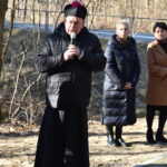 Na obrazku grupy osób, która stoi w parku. Otoczeni są zielenią drzew i różnokolorowych kwiatów, a ich twarze są całkowicie pełne radości i spokoju.