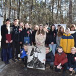 Naruszone jest grupa osób pozujących do zdjęcia przed grobem. Wyrażają pamięć i pamięć o zmarłym, utrwalając dziesięć momentów na fotografii.