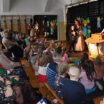 Na zdjęciu uwieczniono tłum osób występujących w jakichkolwiek przedstawieniach. Widzowie są skoncentrowani na scenach, gdzie dzieje się występ.