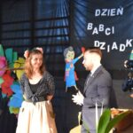 Na zdjęciu stojących obok siebie mężczyzn i kobiet. Wyglądają na towarzyszących sobie, co szczególne ich bliskie położenie względem siebie.