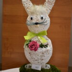 1-Miejsce-w-1-kategorii Na obrazku widnieje dekoracyjna rzeźba królika z muszką i okularami, która jest wystawiona na drewnianym pniu. Królik ma elegancki wygląd dzięki dodatkom, które ma na siebie.