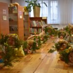 Na obrazku widać dzieci noszące korony z kwiatami, które siedzą przy kradzieży w bibliotece. Wyglądają na zaangażowane i zadowolone, a następnie przedstawiają książkę dotyczącą przestrzegania zasad nauki lub naukowej zabawy.