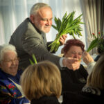 Na obrazku mężczyzn, którzy trzymają w rękach bukiet kwiatów. Look na to, że jest gotowy, aby wręczyć komuś specjalnemu.