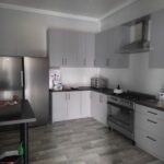 Zdjecie-6 Na obrazku głównym, którego kolorem jest szarość mebli. Kuchnia jest wyposażona w sprzęty ze stali nierdzewnej i mam drewniane podłogi.