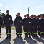 DSC_0031 Na obrazku widoczne grupy osób, które mają na sobie jednakowe czarne mundury z odblaskowymi żółtymi pasami i czerwonymi czapkami. Stoją jeden w zwartym zagrożeniu na rozprzestrzenianie się powietrza, które może nastąpić w wyniku działania z publicznej lub społecznością.