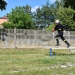 DSC_0199 Na obrazku żołnierza i kasku biegnie po wyjściu z ćwiczeń szkoleniowych na zewnątrz. W tle widać drzewo i ogrodzenie.