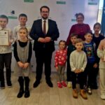 484927457_675895324785992_1411462893601531284_n Na ekranie pojawia się grupa dzieci i dwoje dorosłych, którzy pozują w pomieszczeniu. Jeden z dorosłych oraz dwoje dzieci trzymają certyfikaty, a wszyscy są zobowiązani do przestrzegania prawa przed tłem z logo.