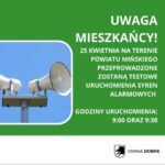 Zdjęcie przedstawia biały głośnik na niebieskim tle. Po prawej stronie znajduje się zielone tło z białym tekstem. Informuje ono o testach syren 25 kwietnia.