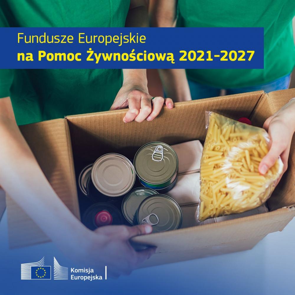 Osoby w zielonych koszulkach trzymają karton z żywnością: makaron i konserwy. Niebieski baner informuje o funduszach UE 2021-2027. W tle logo Komisji Europejskiej.