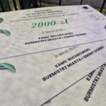 500261190_727959246246266_1954653264778063941_n Nagroda za zawody, czek na 2000 zł, biały z zieloną kokardą. Widoczne logo straży pożarnej i herb. Daty i nazwiska na czeku.