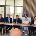 IMG_20250630_110221 Grupa ludzi siedzi za długim stołem w sali konferencyjnej. Tło z drewnianymi panelami, godła na ścianie. Elegancka atmosfera spotkania.