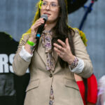 Żółte i kolorowe kwiaty W tle mały czerwony płotek z kolorowymi kwiatami