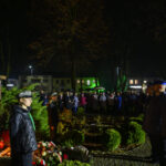 DSC_5563 Pomnik Piłsudskiego z boku, ciemna noc. Ludzie wokół, światła z tyłu. Zieleń i znicze pod pomnikiem.